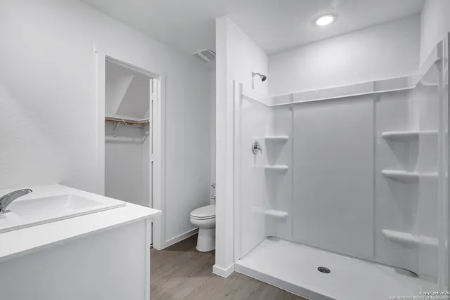 a bathroom with a shower a toilet and sink