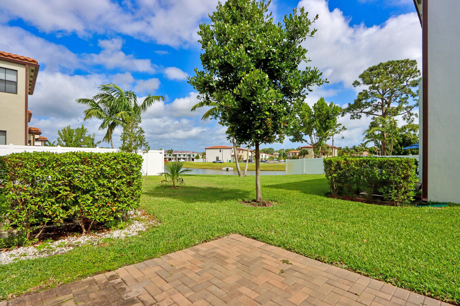 6024 Pine Tree Way Riviera Beach, FL 33410 - Photo 24 of 26 a view of a garden with a building in the background