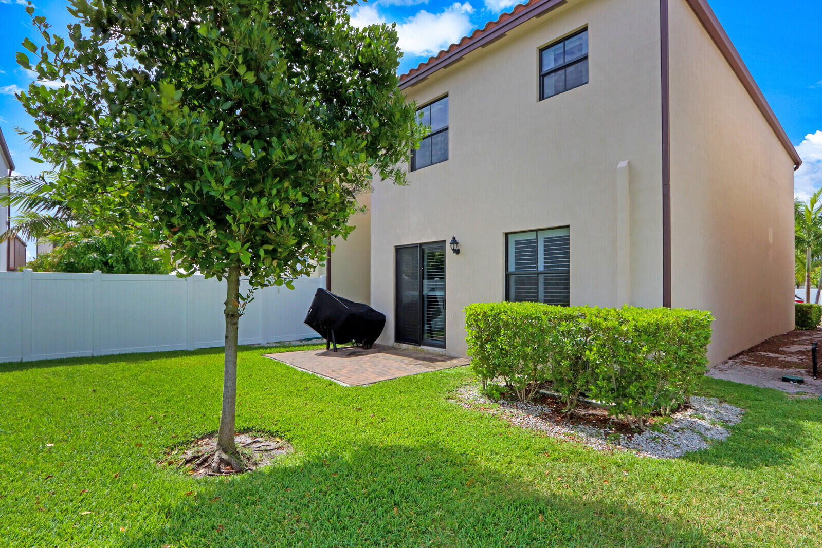 6024 Pine Tree Way Riviera Beach, FL 33410 - Photo 25 of 26 a view of a backyard with table and chairs and potted plants