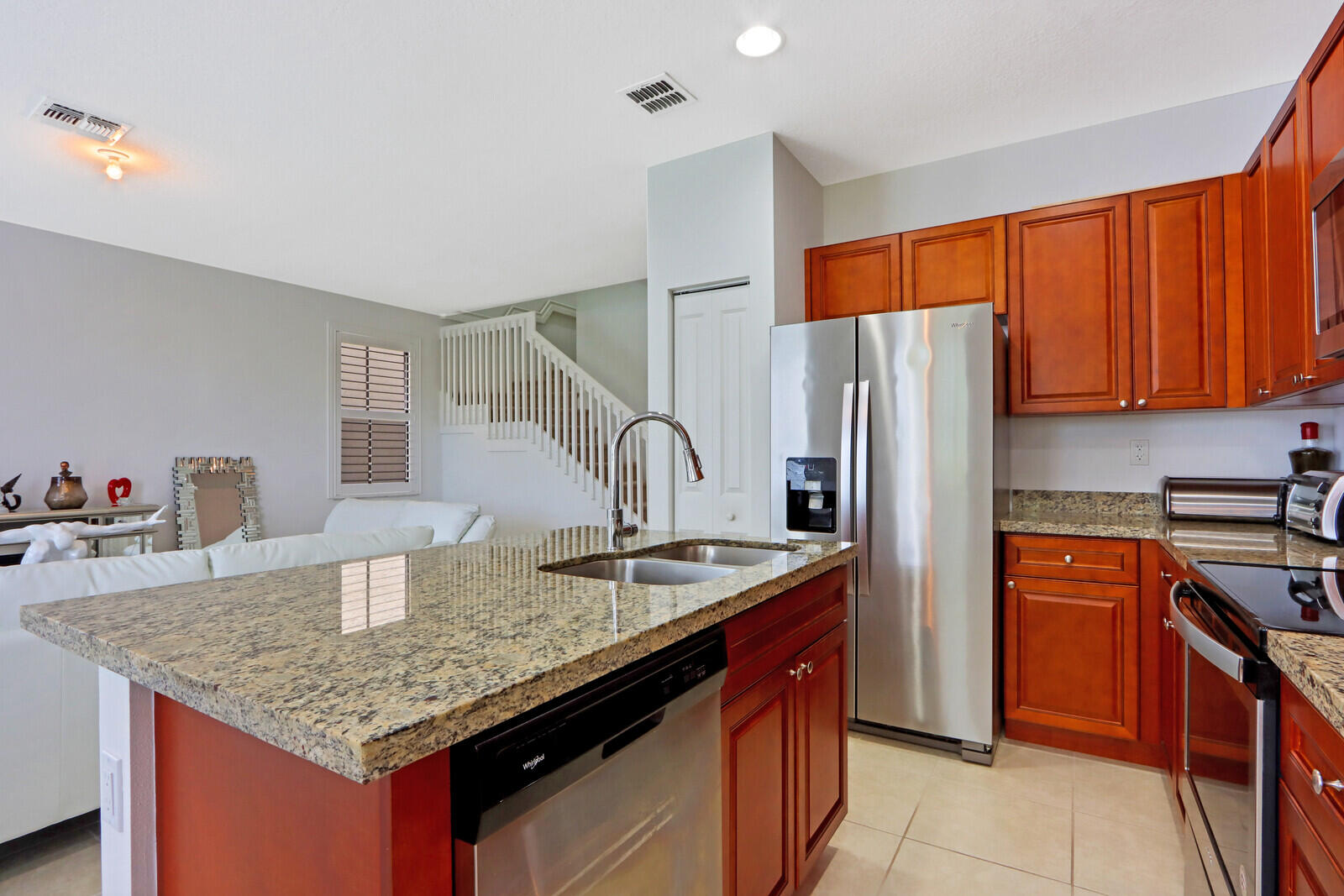 6024 Pine Tree Way Riviera Beach, FL 33410 - Photo 10 of 26 a kitchen with granite countertop kitchen island stainless steel appliances granite countertop a sink refrigerator and cabinets