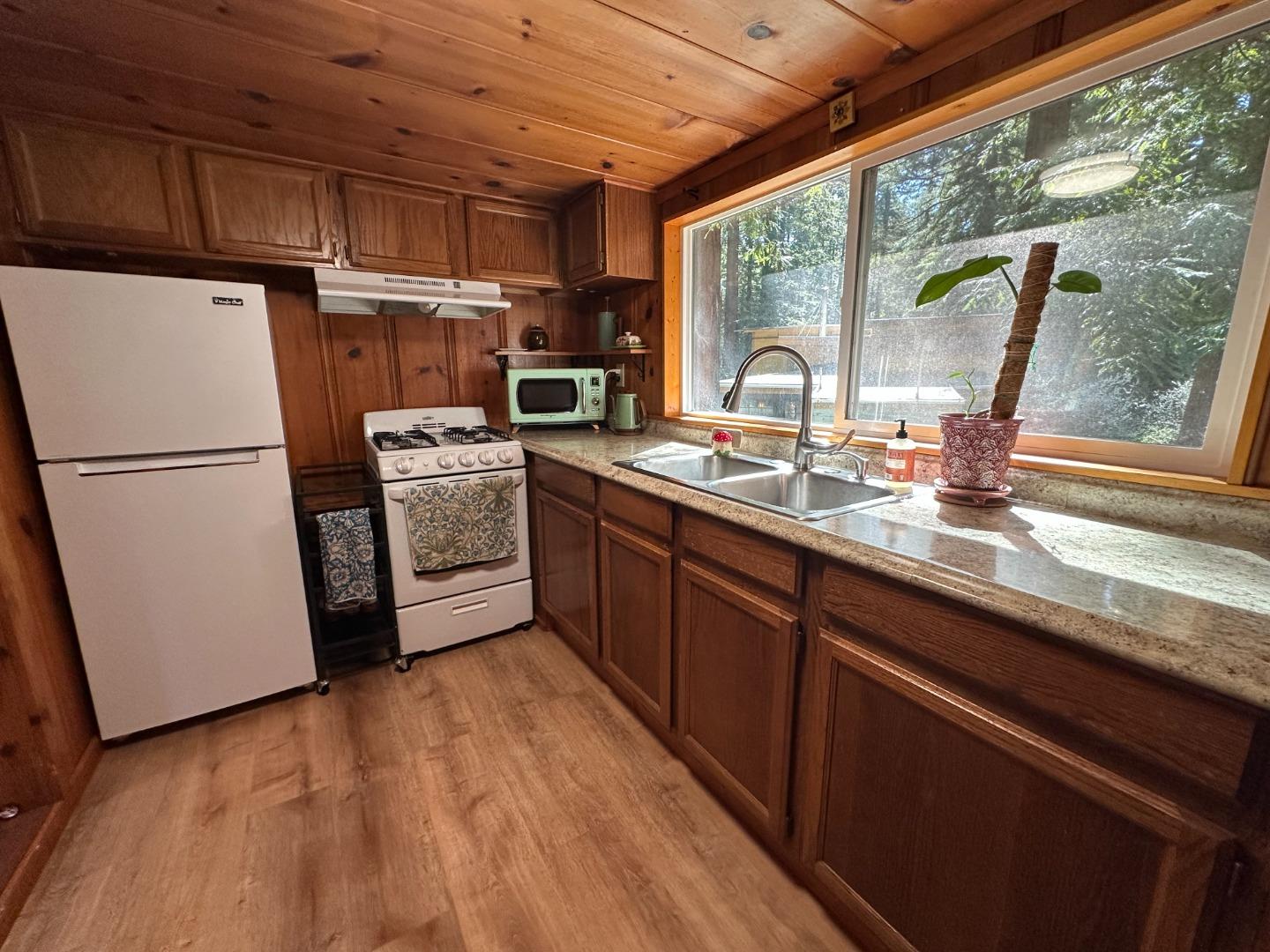 155 McGaffigan Mill Road Boulder Creek, CA 95006 - Photo 7 of 23 a kitchen with a sink a refrigerator and window