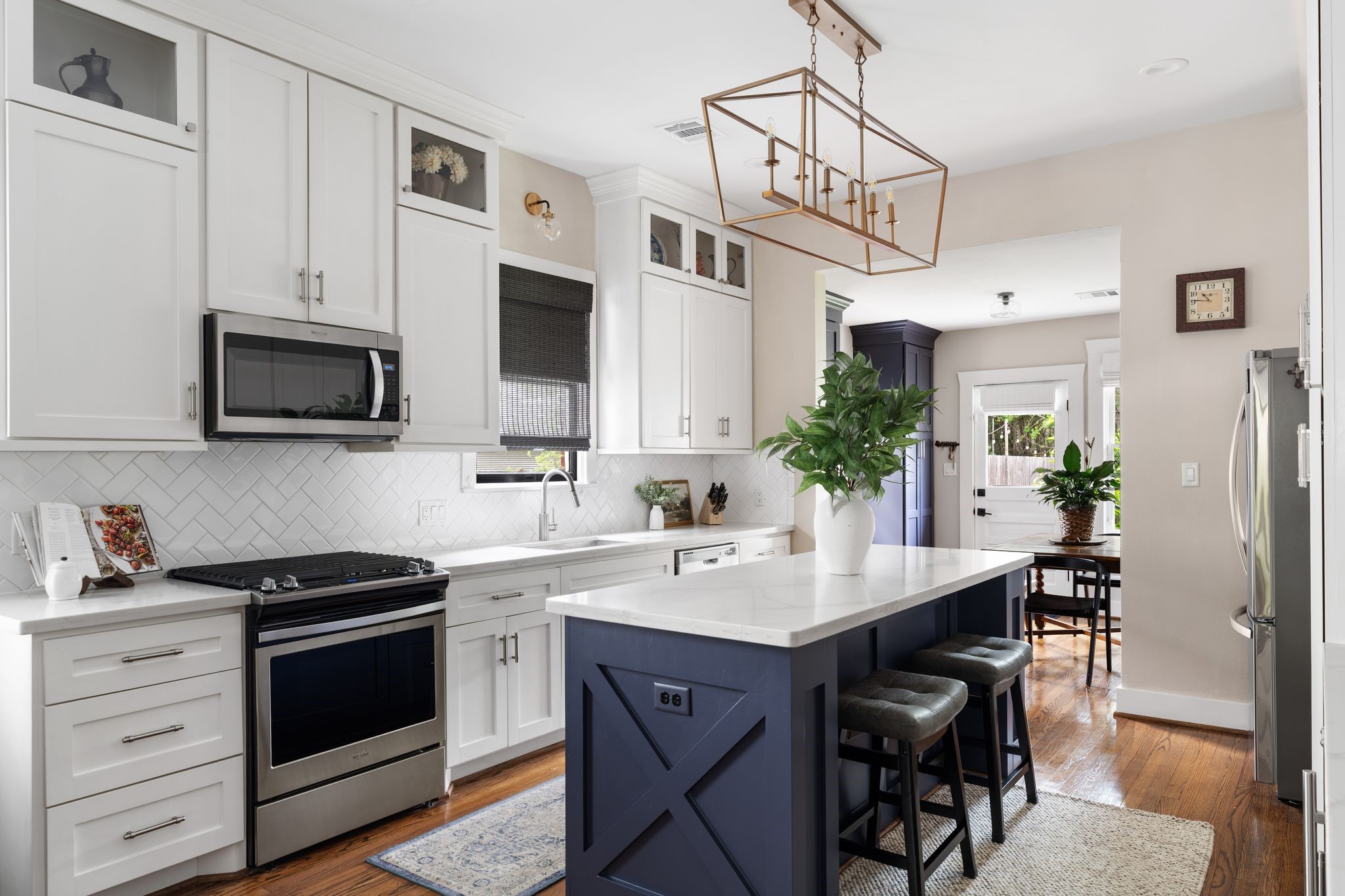 3206 Morrison Street Houston, TX 77009 - Photo 8 of 30 Boasting sleek modern cabinetry that extends to the ceiling, gleaming quartz countertops, stainless steel appliances, a wine fridge, and a dry bar area.