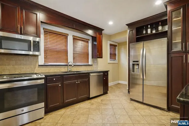 a kitchen with stainless steel appliances granite countertop a refrigerator and a sink
