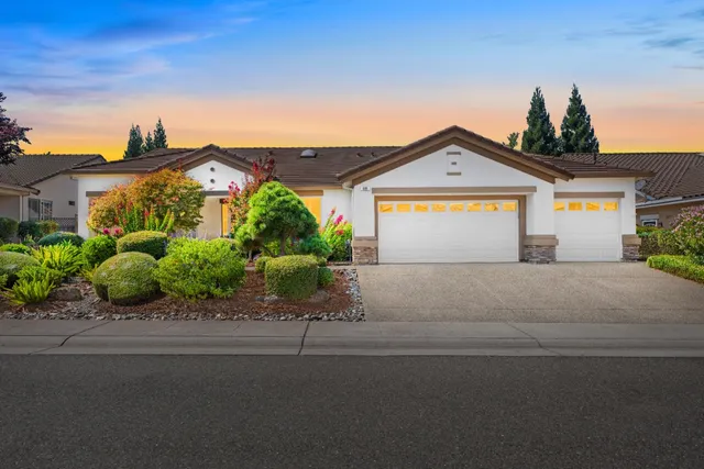 a front view of a house with a yard and a garage