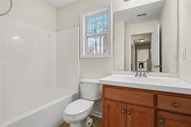 a bathroom with a sink toilet vanity mirror and tub