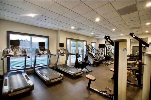 a room with gym equipment and large mirror