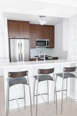 a kitchen with a table chairs refrigerator and microwave