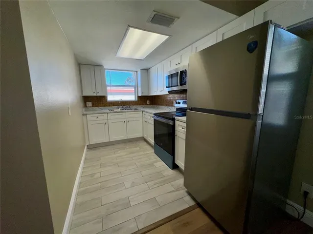 a kitchen with a refrigerator stove and sink