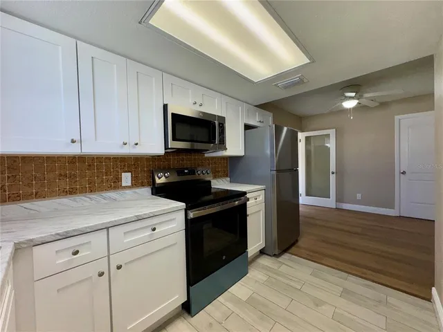 an empty room with wooden floor and a bathroom
