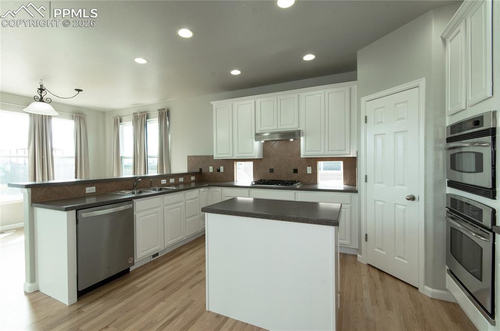 9443 St.George Road Peyton, CO 80831 - Photo 17 of 45 a kitchen with stainless steel appliances granite countertop a stove and a refrigerator