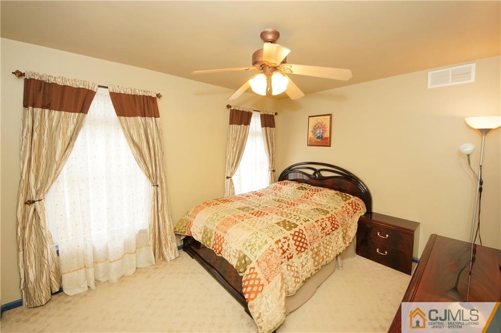 13 Timber Ridge Road North Brunswick, NJ 08902 - Photo 20 of 24 a bedroom with a bed and a chandelier