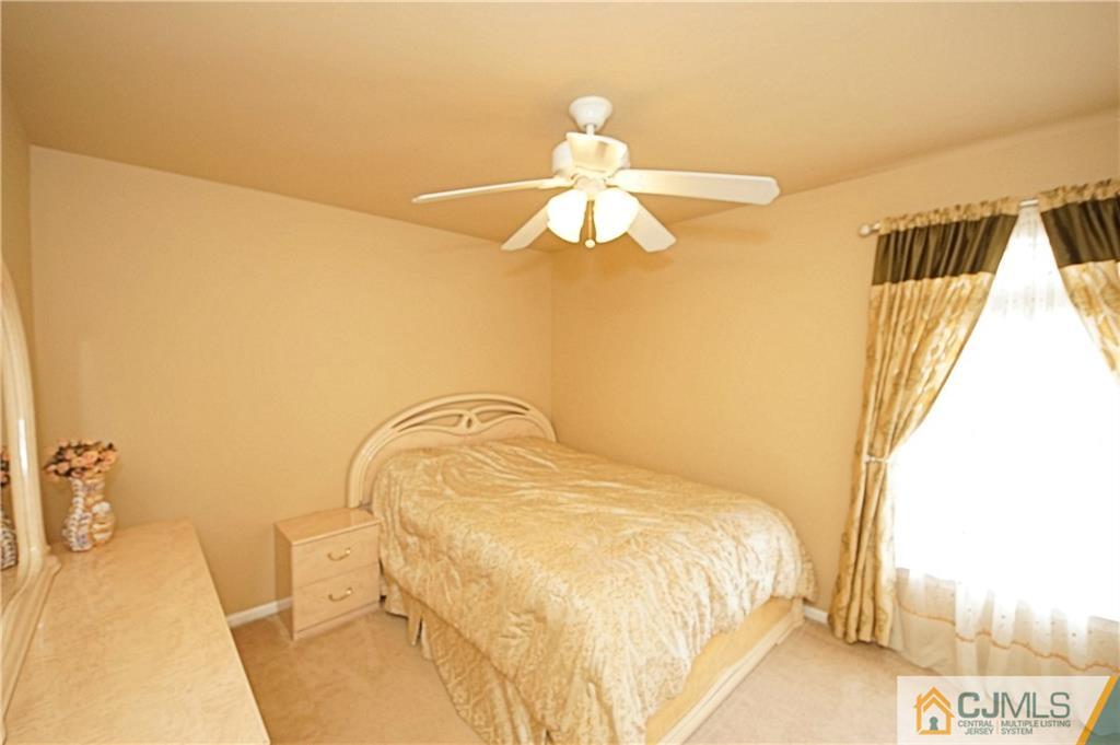 13 Timber Ridge Road North Brunswick, NJ 08902 - Photo 21 of 24 a bedroom with a bed and a chandelier
