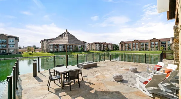 a patio with water view fountain and a big yard