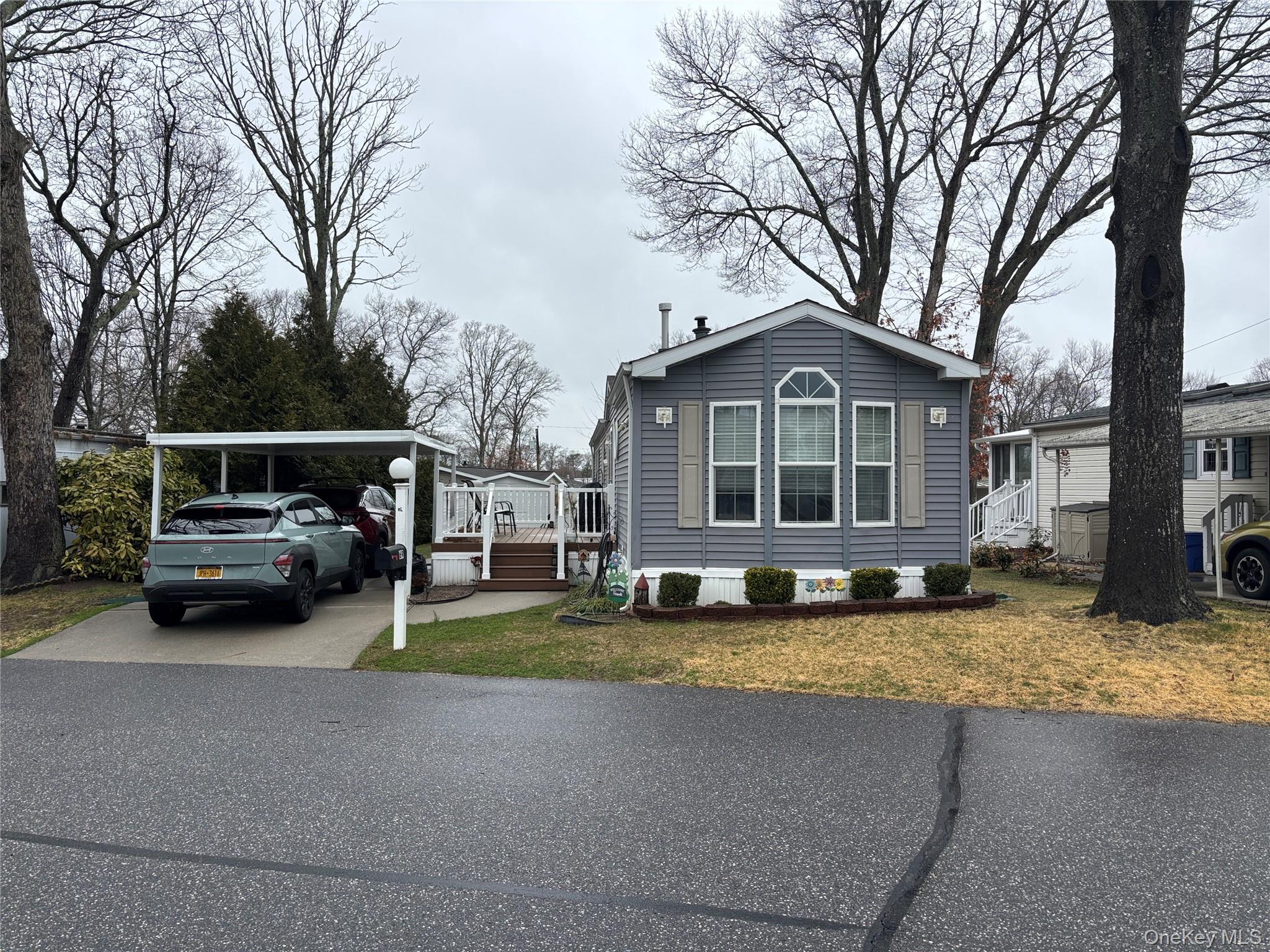 a view of a house with a big yard and large trees