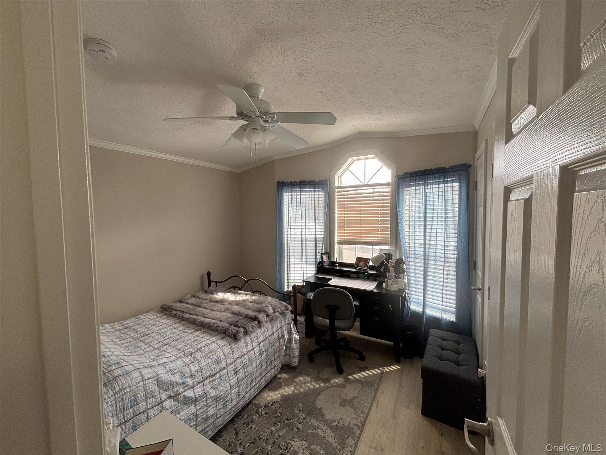 1661 Old Country Road, Unit 69 Riverhead, NY 11901 - Photo 12 of 37 a bedroom with a bed a couch and a chandelier
