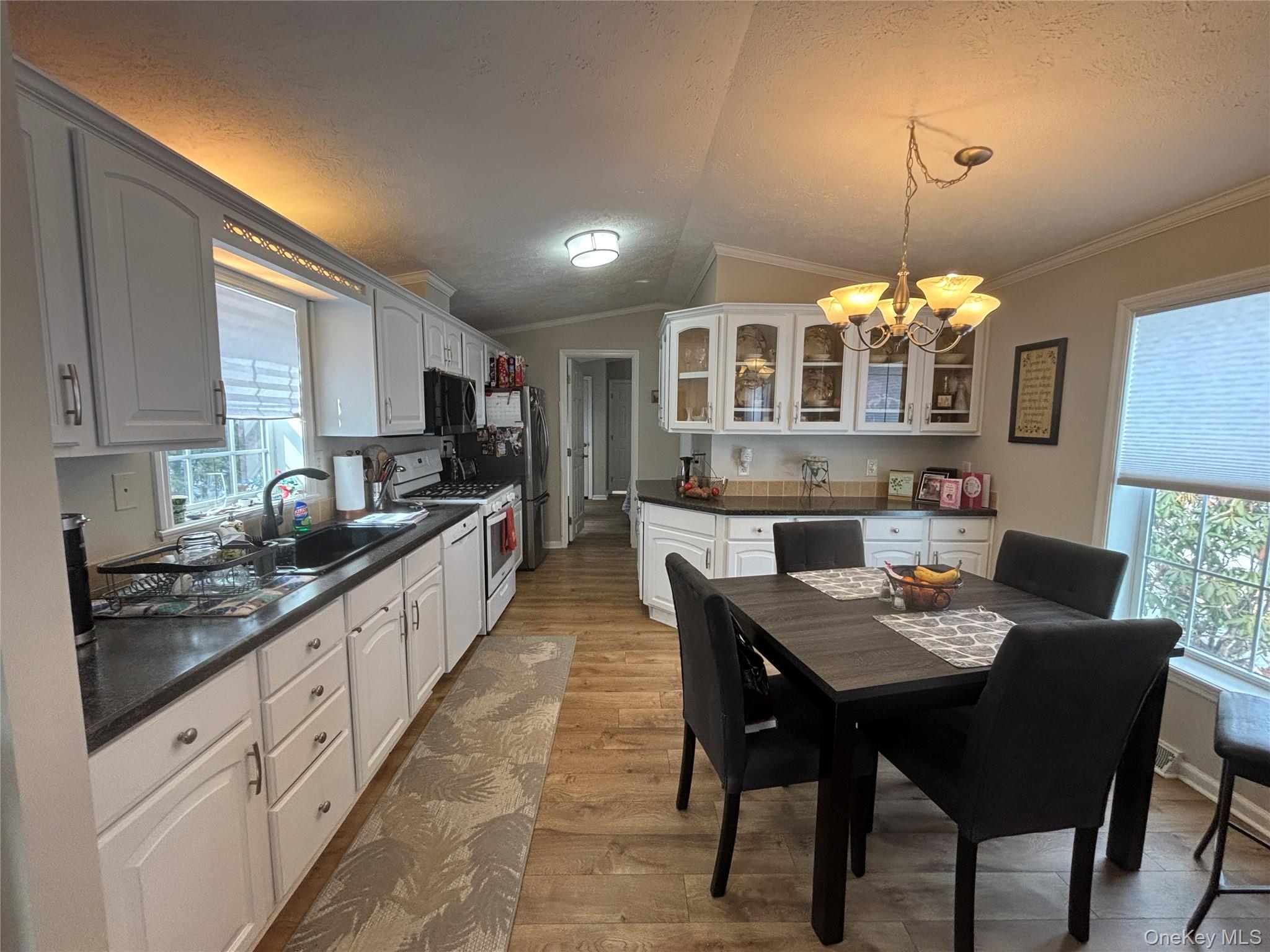1661 Old Country Road, Unit 69 Riverhead, NY 11901 - Photo 17 of 37 a kitchen with granite countertop a stove a sink a dining table and chairs