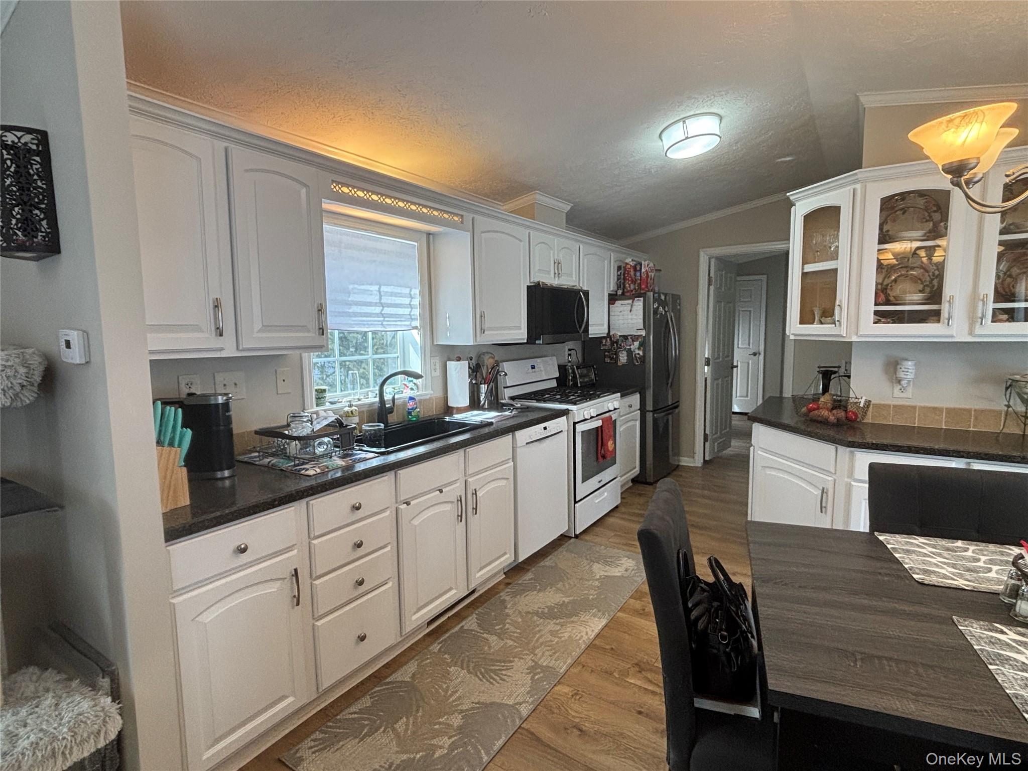 1661 Old Country Road, Unit 69 Riverhead, NY 11901 - Photo 18 of 37 a large kitchen with granite countertop a stove a sink a window and dining table