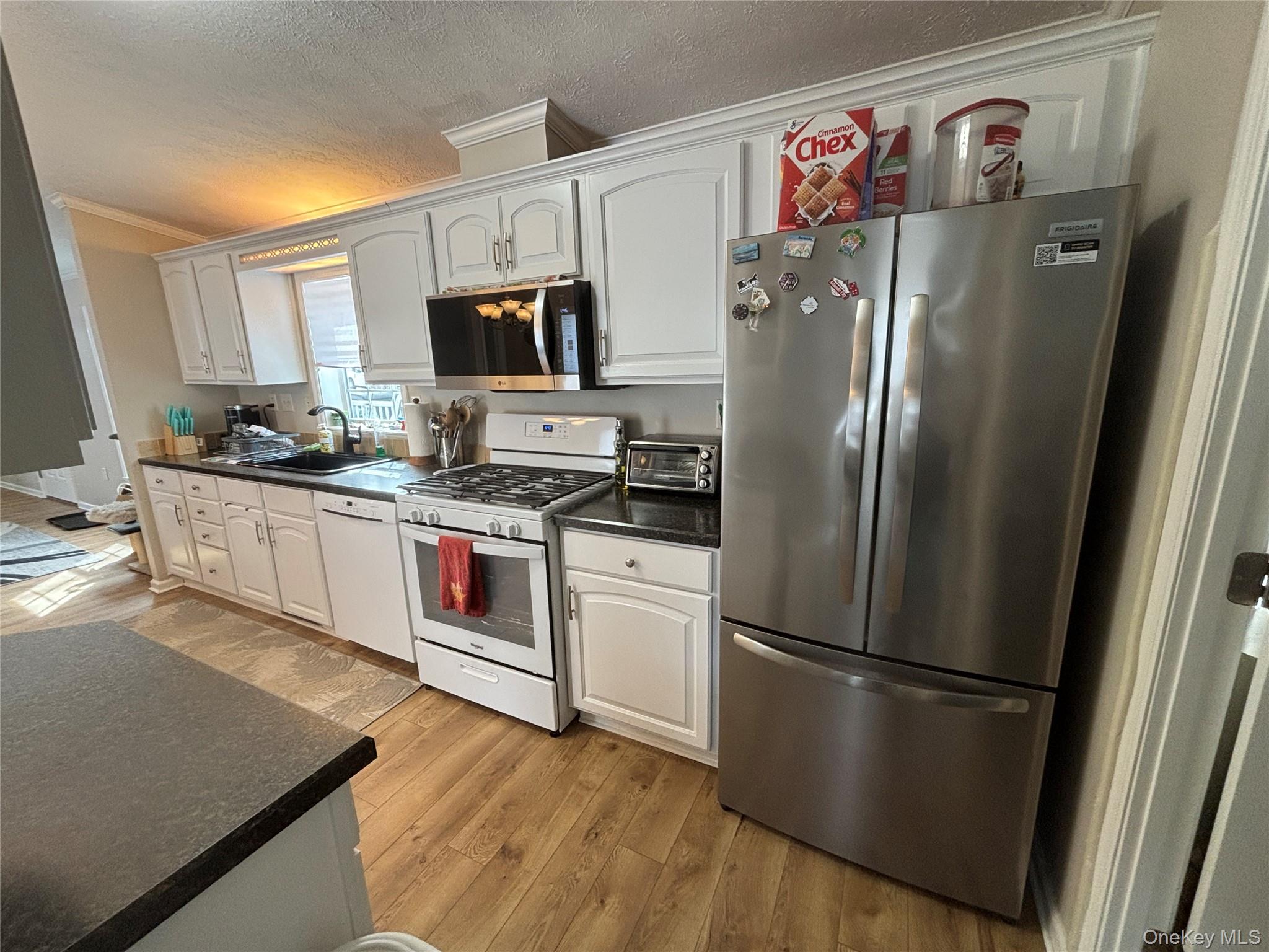 1661 Old Country Road, Unit 69 Riverhead, NY 11901 - Photo 20 of 37 a kitchen with stainless steel appliances a refrigerator sink and microwave