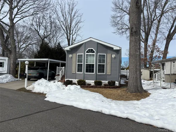 a front view of a house with a yard covered with snow in front of house
