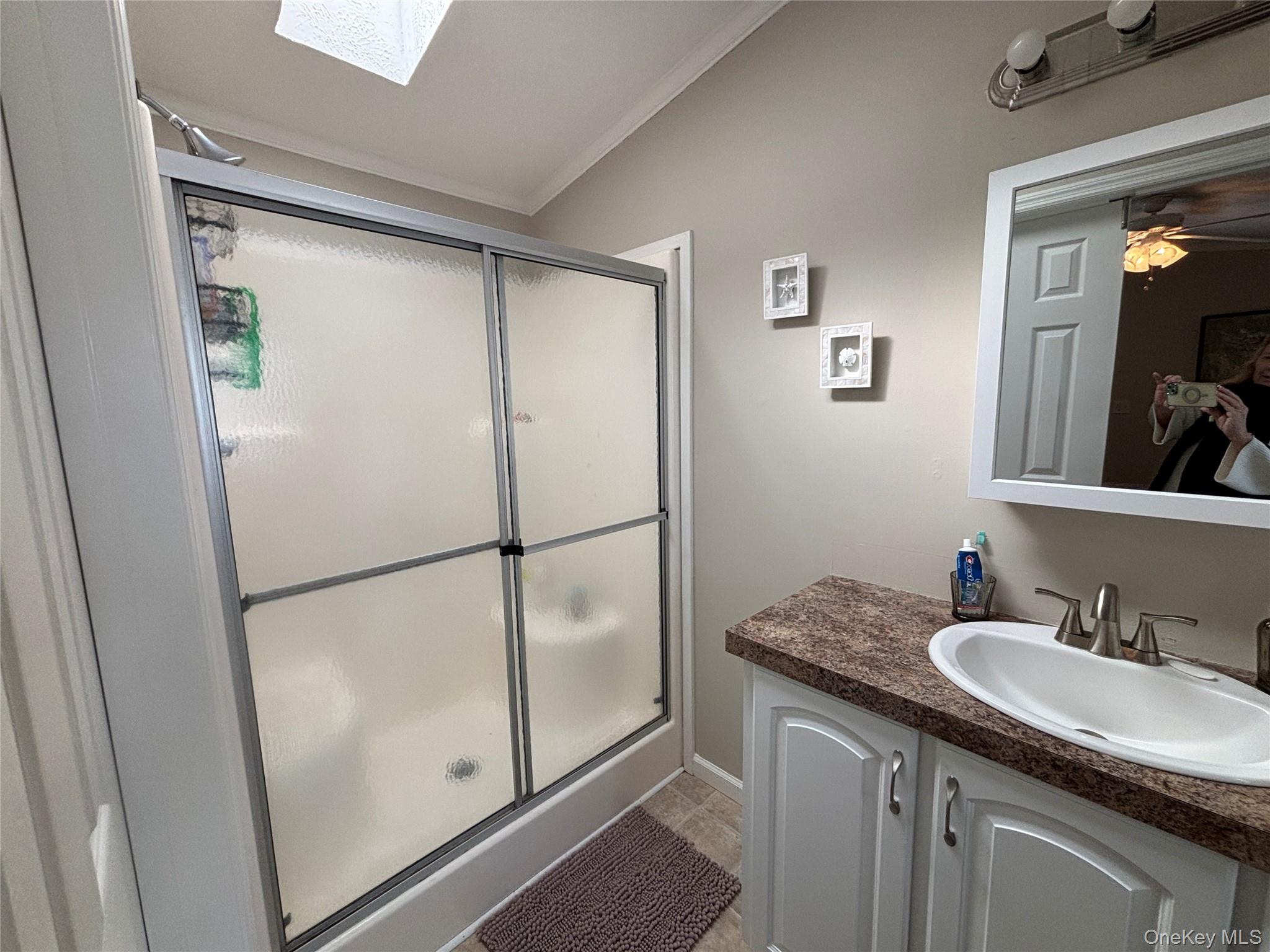 1661 Old Country Road, Unit 69 Riverhead, NY 11901 - Photo 25 of 37 a bathroom with a granite countertop shower sink and mirror