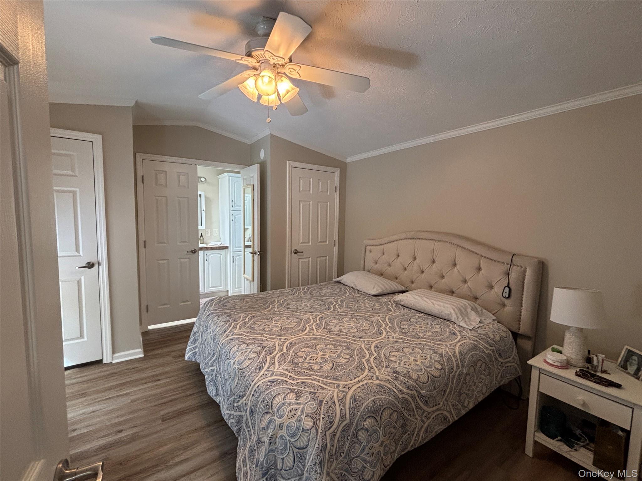1661 Old Country Road, Unit 69 Riverhead, NY 11901 - Photo 26 of 37 a bedroom with a bed and a chandelier