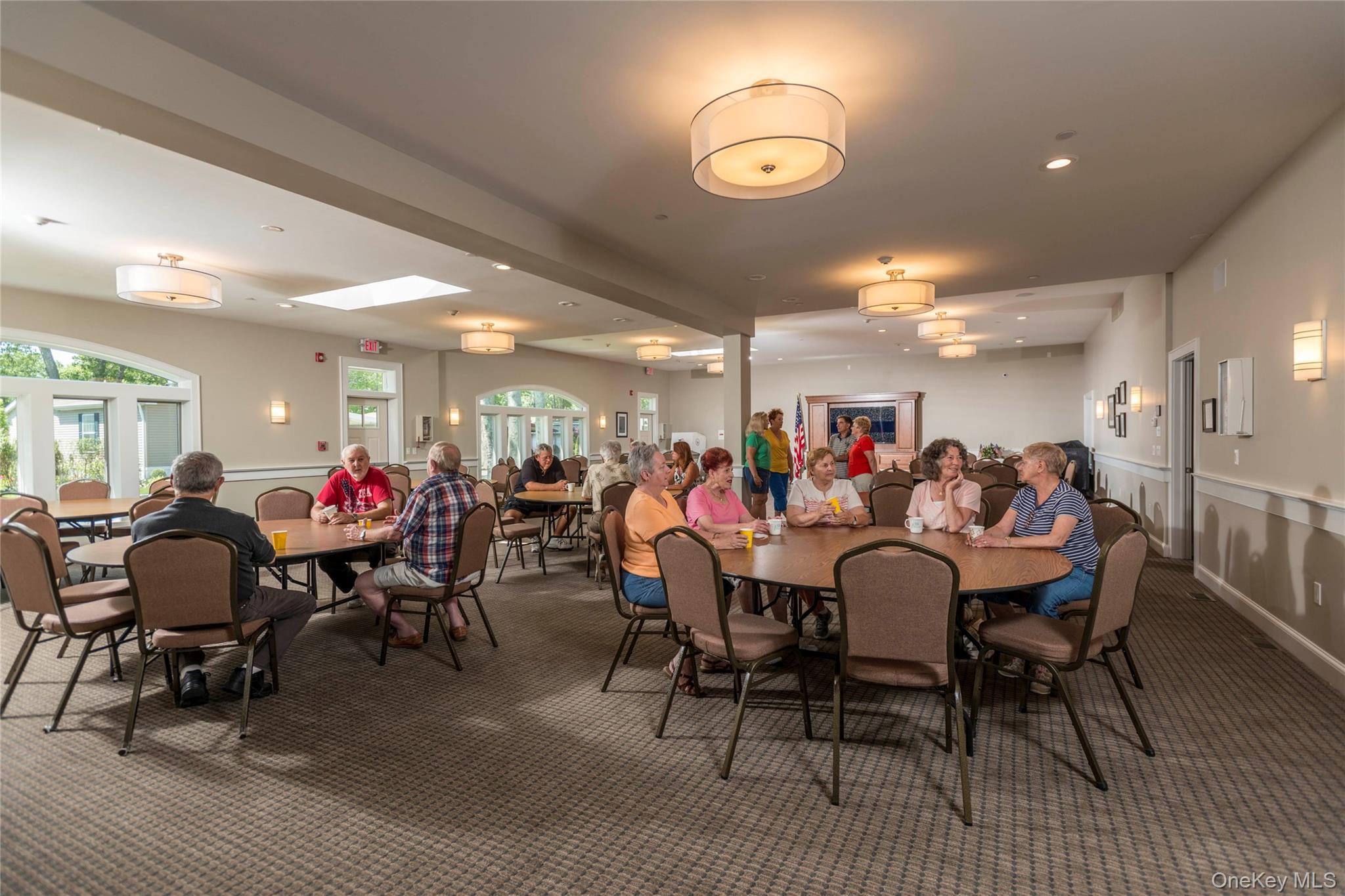 1661 Old Country Road, Unit 69 Riverhead, NY 11901 - Photo 33 of 37 a group of people sitting on a dining room with furniture