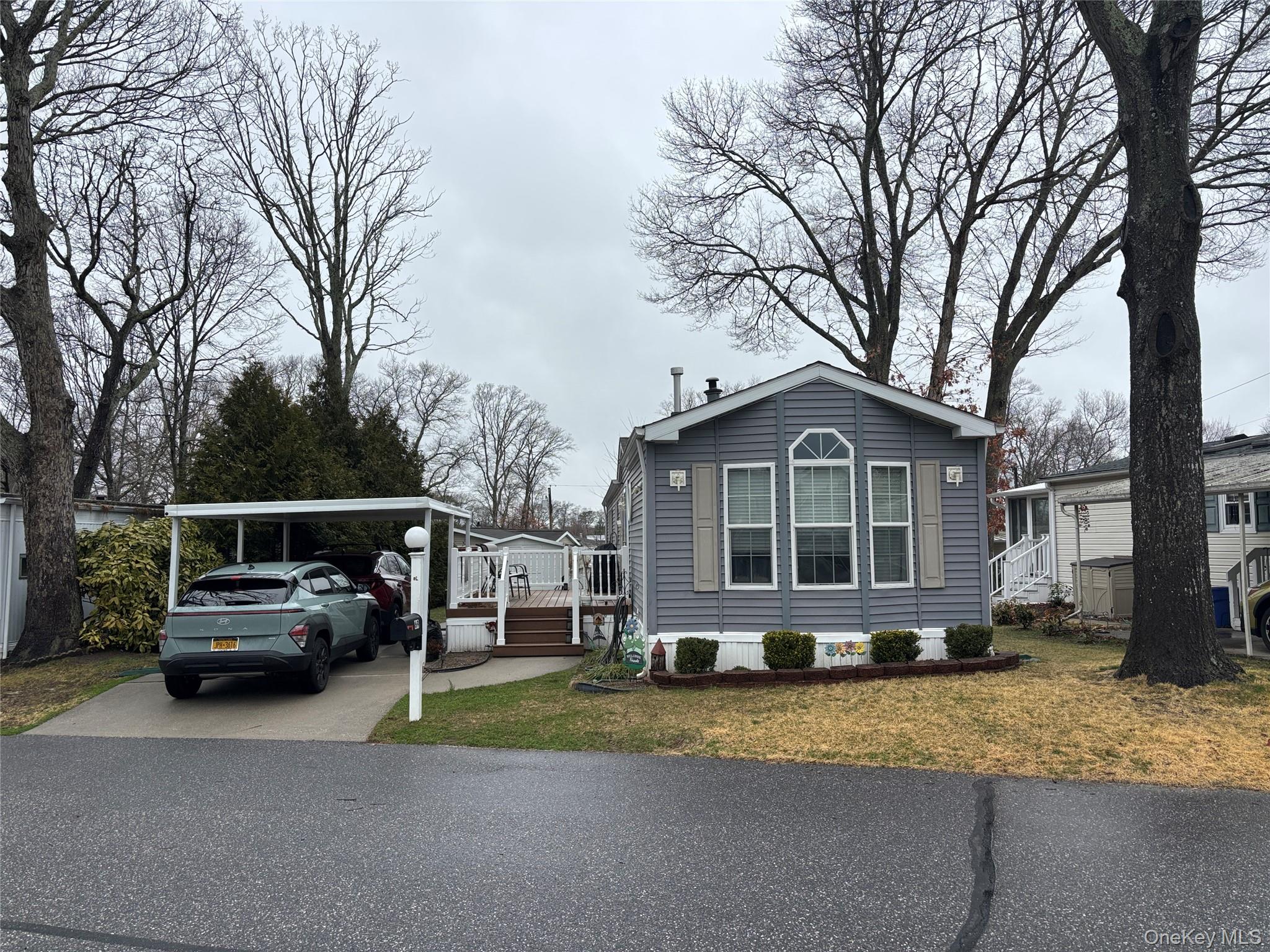 1661 Old Country Road, Unit 69 Riverhead, NY 11901 - Photo 37 of 37 a front view of a house with a garden and tree