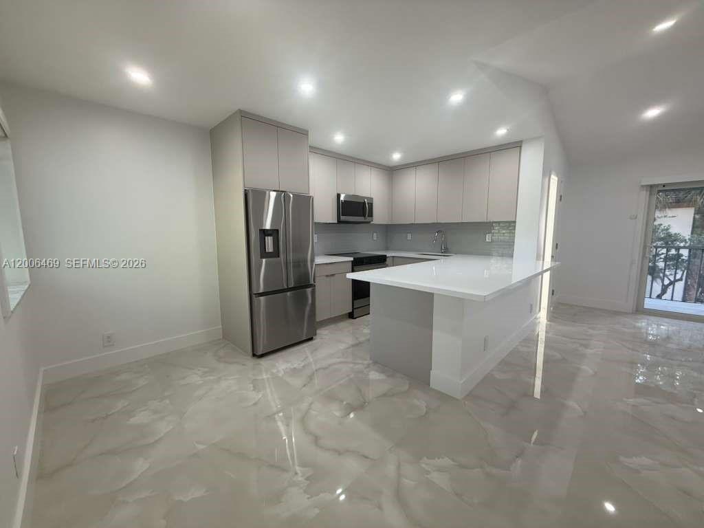 9307 Southwest 138th Place, Unit 9307 Miami, FL 33186 - Photo 2 of 15 a kitchen with stainless steel appliances granite countertop a refrigerator and a sink