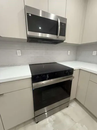 a stove top oven sitting inside of a kitchen