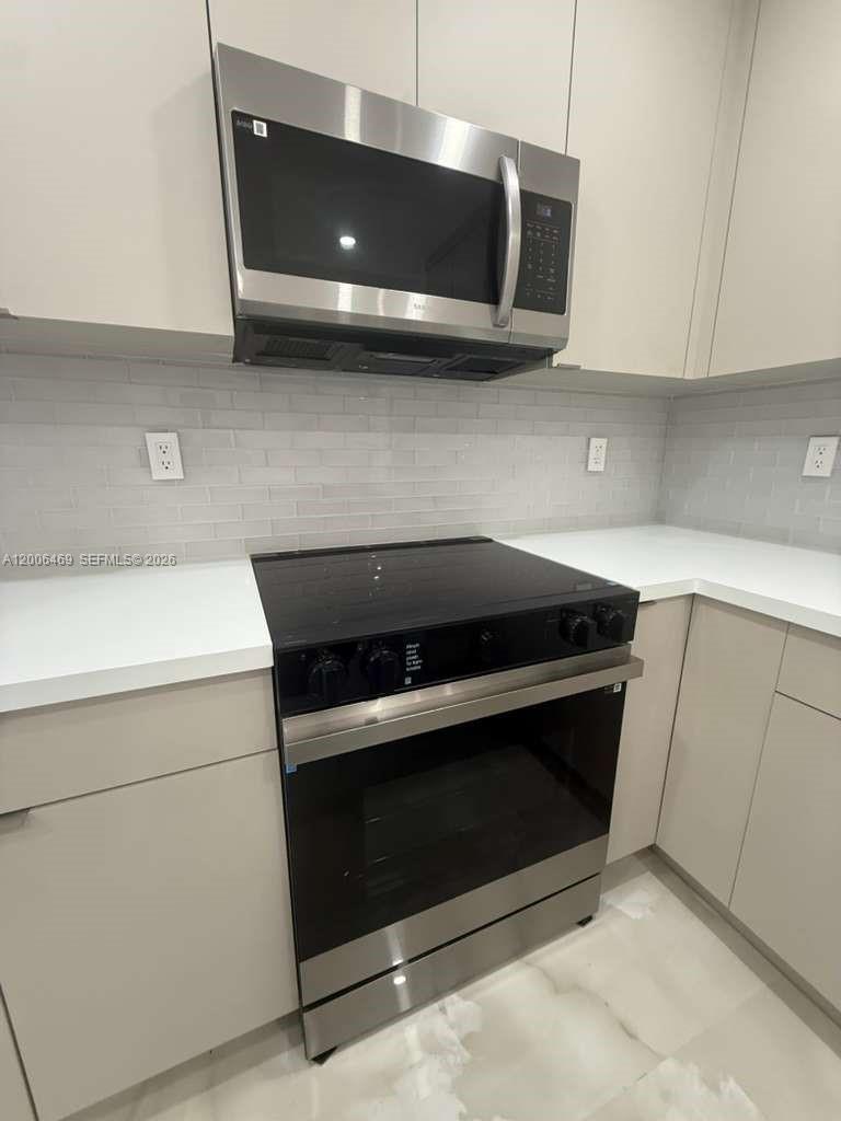 9307 Southwest 138th Place, Unit 9307 Miami, FL 33186 - Photo 3 of 15 a stove top oven sitting inside of a kitchen