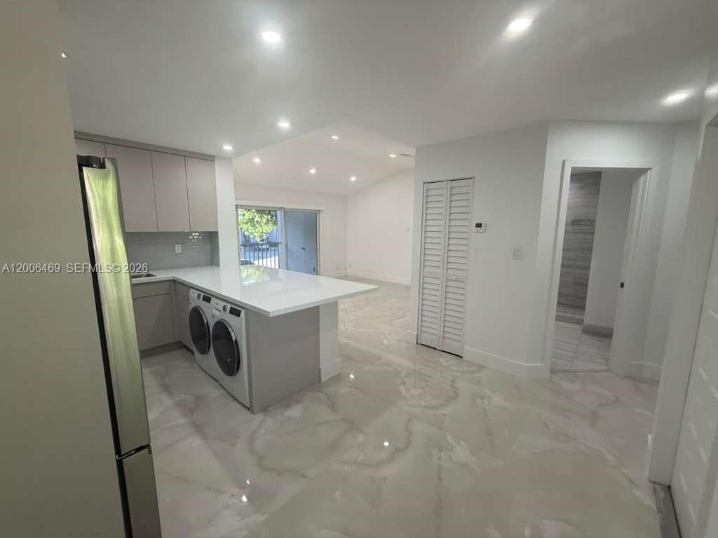 9307 Southwest 138th Place, Unit 9307 Miami, FL 33186 - Photo 4 of 15 a room with a washing machine and a sink