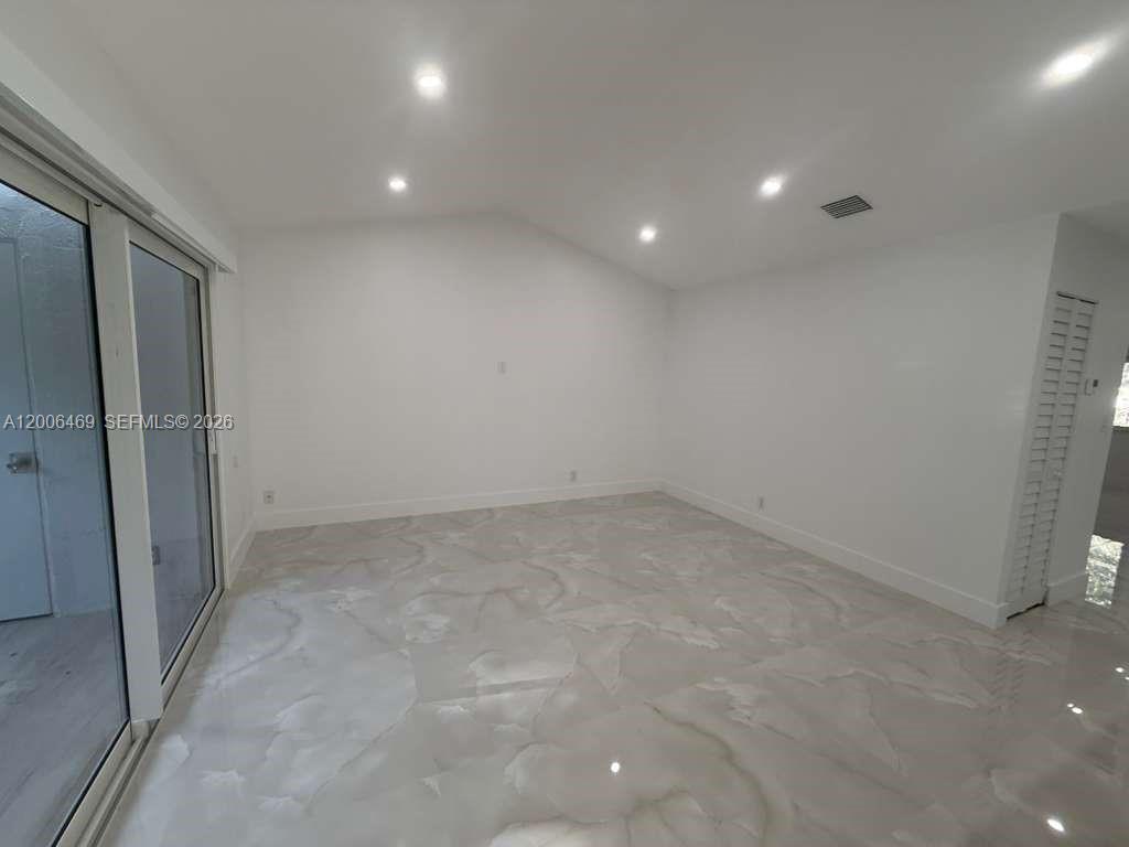 9307 Southwest 138th Place, Unit 9307 Miami, FL 33186 - Photo 6 of 15 an empty room with a natural light