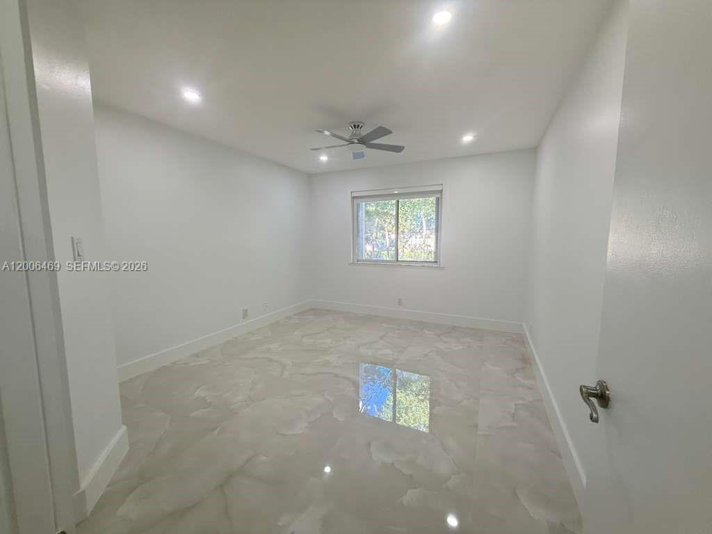 9307 Southwest 138th Place, Unit 9307 Miami, FL 33186 - Photo 8 of 15 en empty room with windows and ceiling fan