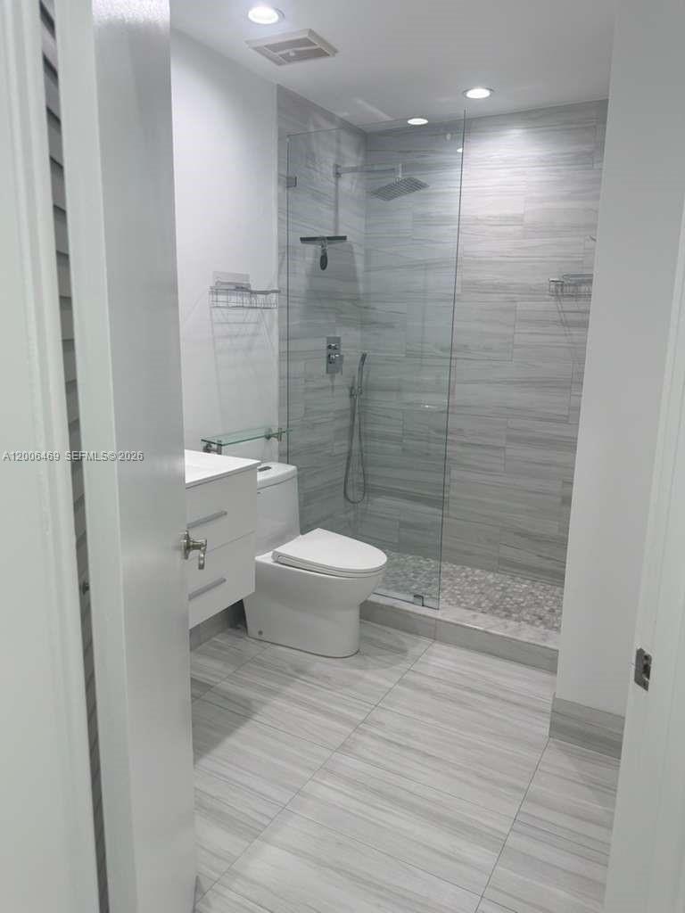 9307 Southwest 138th Place, Unit 9307 Miami, FL 33186 - Photo 9 of 15 a bathroom with a toilet and a shower