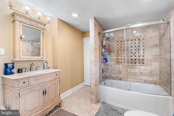 a bathroom with a bathtub a mirror a sink and shower