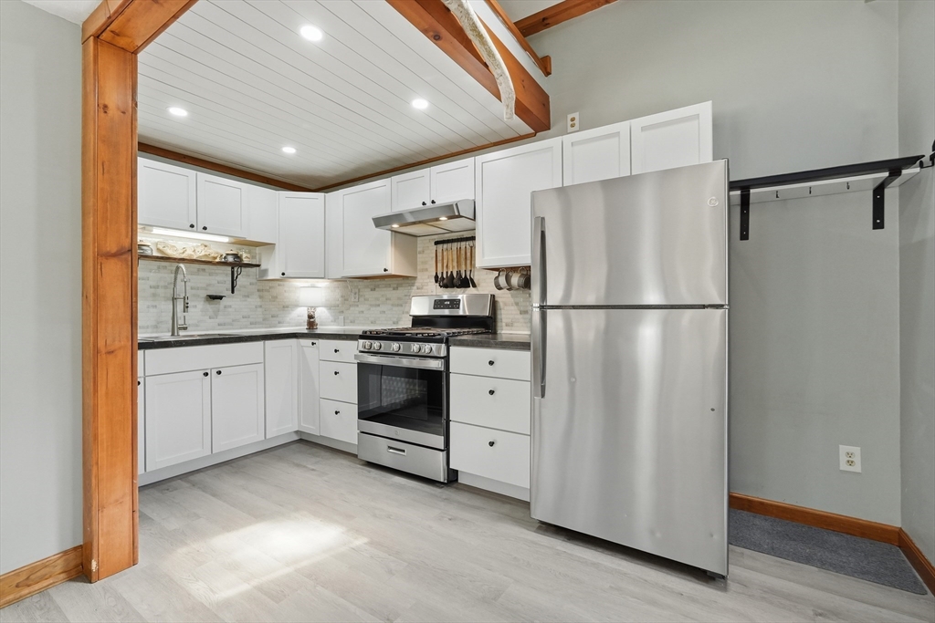 136 Flynt Street Palmer, MA 01069 - Photo 5 of 28 a kitchen with white cabinets stainless steel appliances and a refrigerator