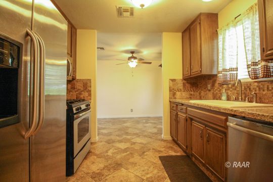 941 West Boston Avenue Ridgecrest, CA 93555 - Photo 4 of 23 a kitchen with stainless steel appliances granite countertop a refrigerator and a sink