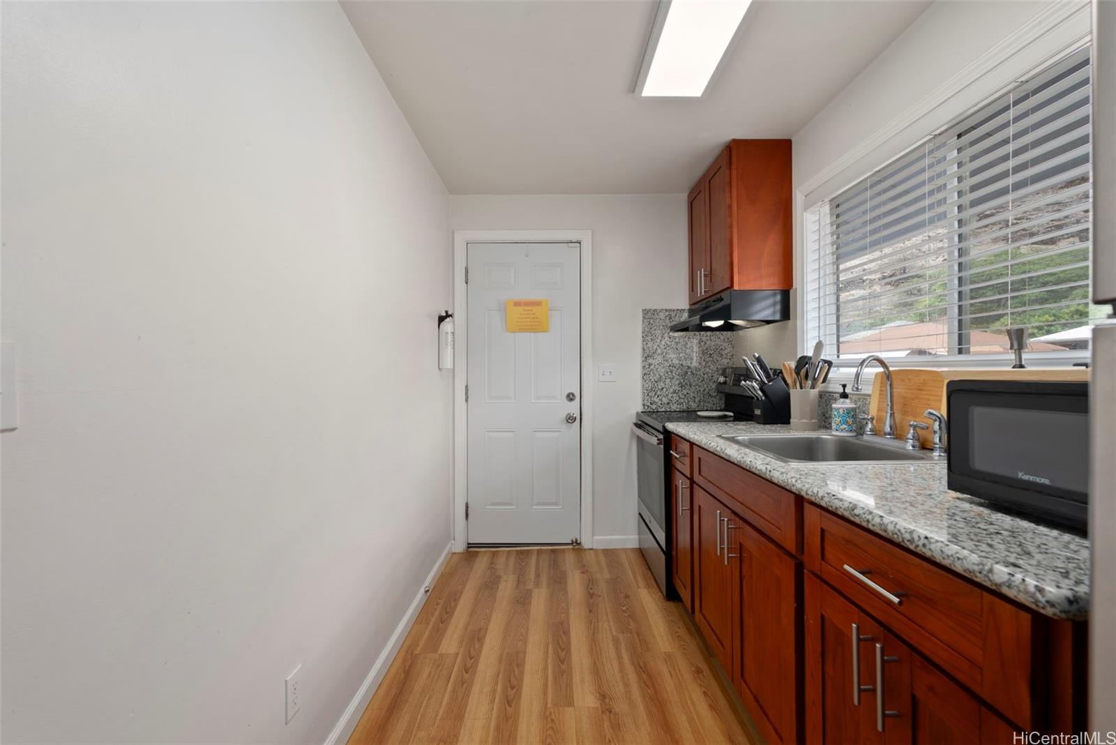87-1423 Akowai Road Waianae, HI 96792 - Photo 14 of 24 a kitchen with sink a window and cabinets