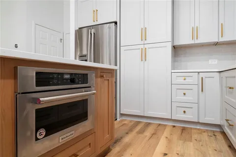 a kitchen with granite countertop white cabinets and stainless steel appliances