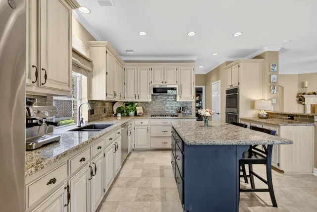 a kitchen with stainless steel appliances granite countertop a stove refrigerator sink and cabinets