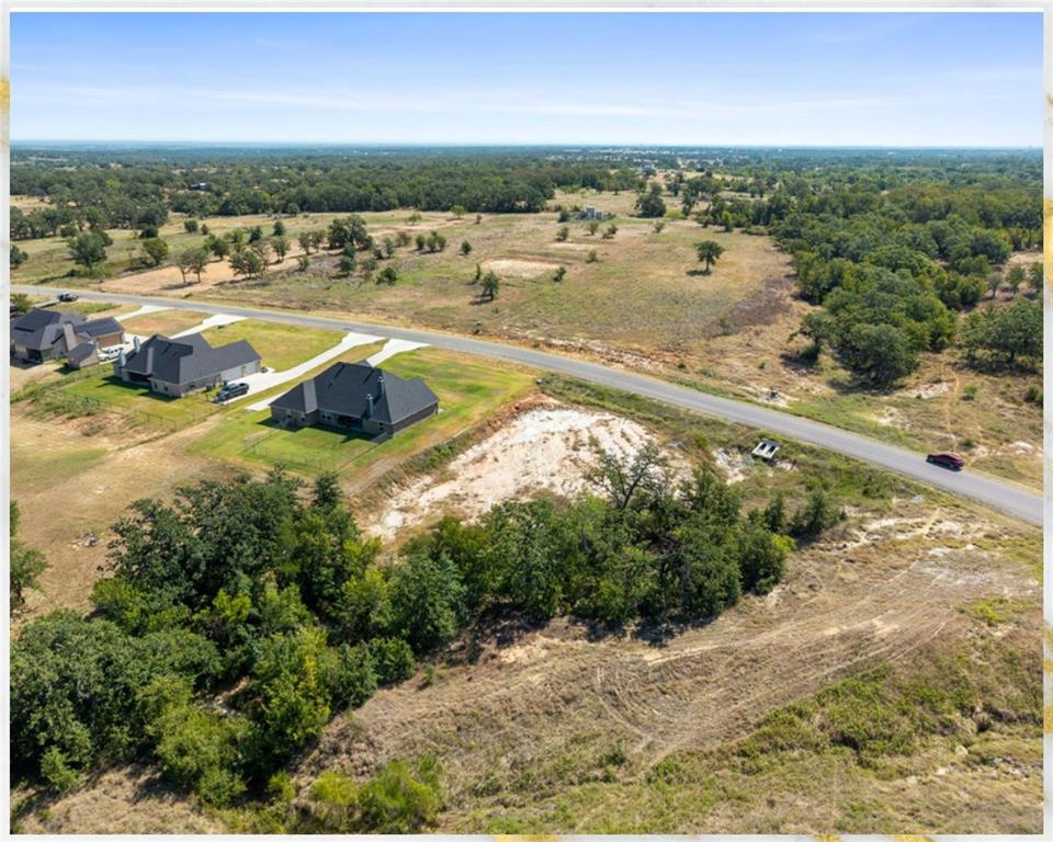 1077 Gonzollas Road Springtown, TX 76082 - Photo 7 of 13 Expansive undeveloped land featuring a cleared section, natural tree coverage, and direct road frontage
