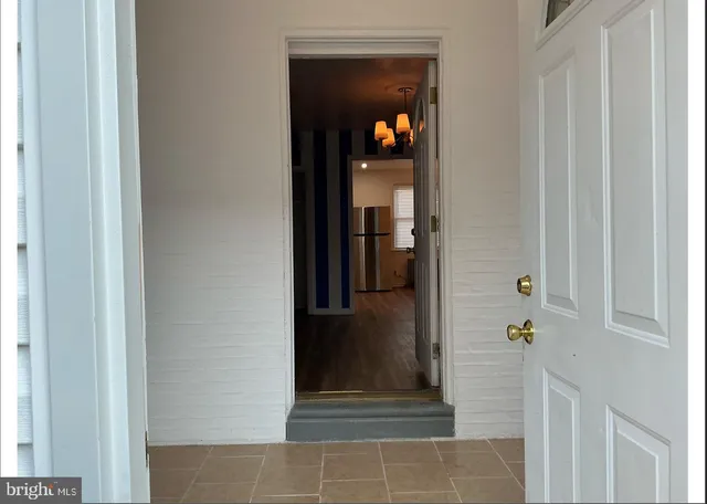 a view of a hallway with wooden floor and a living room