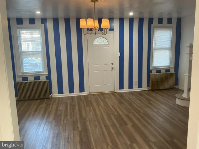 a view of a hallway to a livingroom with furniture wooden floor and window