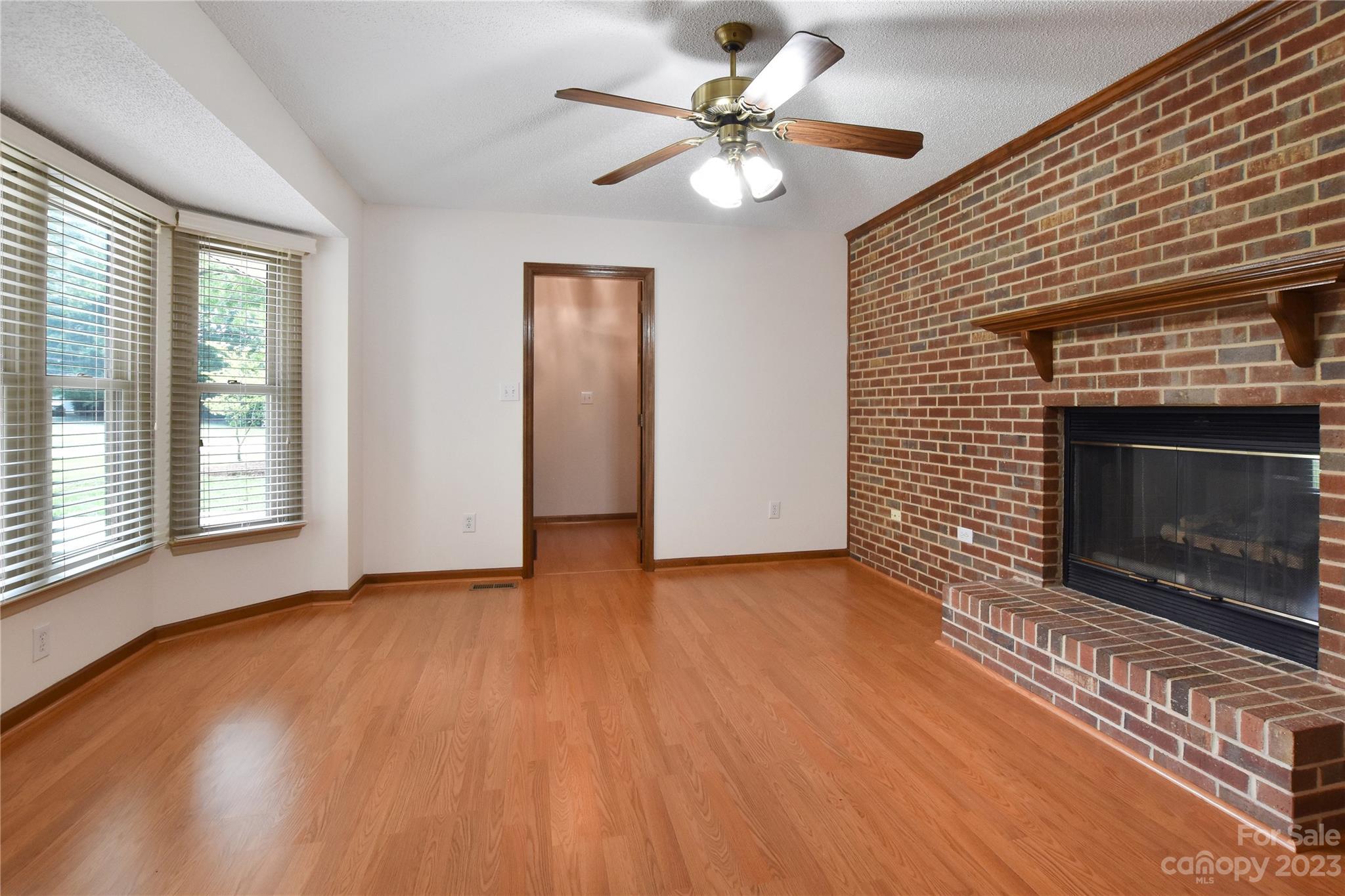 3075 Stoneybrook Drive Fort Mill, SC 29708 - Photo 10 of 31 a view of an empty room with wooden floor fireplace and a window