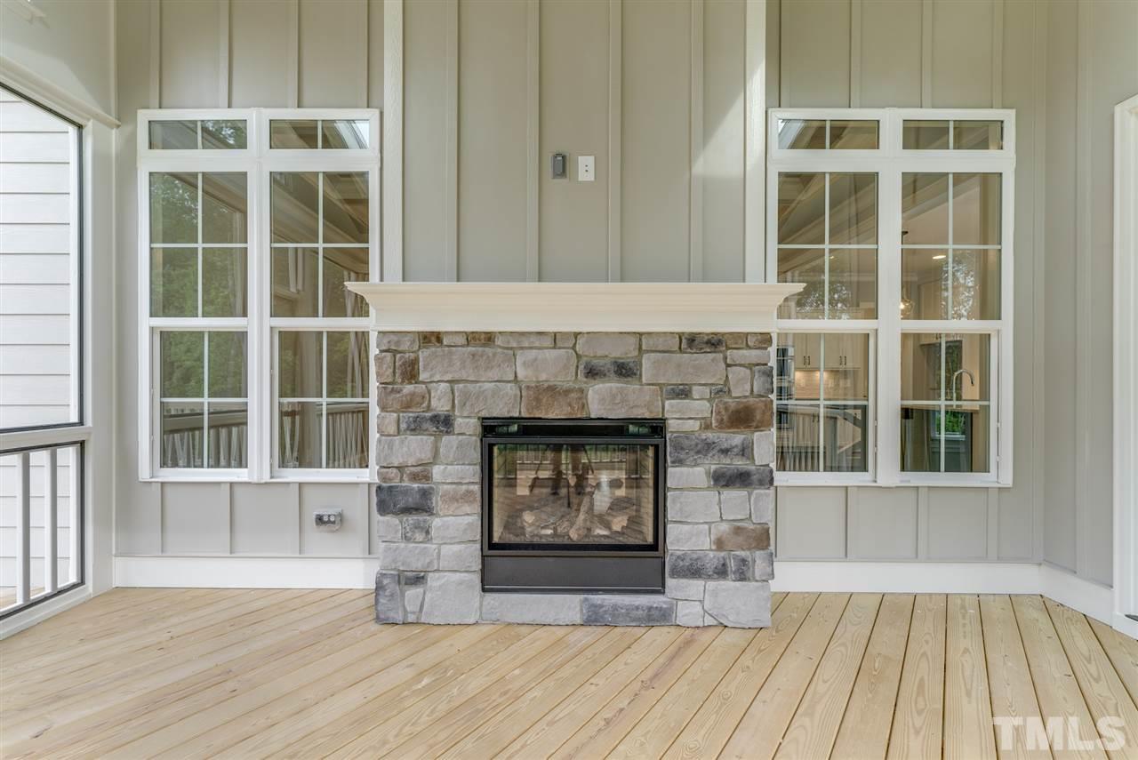 113 Roseroot Court Holly Springs, NC 27540 - Photo 16 of 25 an empty room with wooden floor and a fireplace