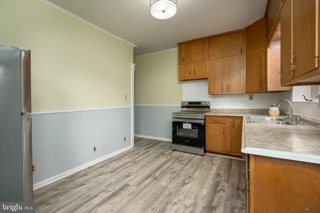 a kitchen with granite countertop a stove a sink and a refrigerator