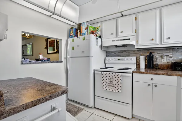 a kitchen with granite countertop a sink a stove and cabinets