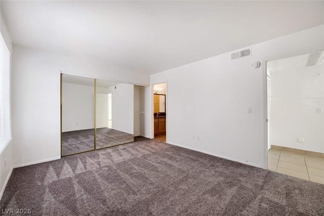 9325 West Desert Inn Road, Unit 177 Las Vegas, NV 89117 - Photo 18 of 24 A spacious sleeping area features soft carpeting, ample natural light, and convenient mirrored closet doors.