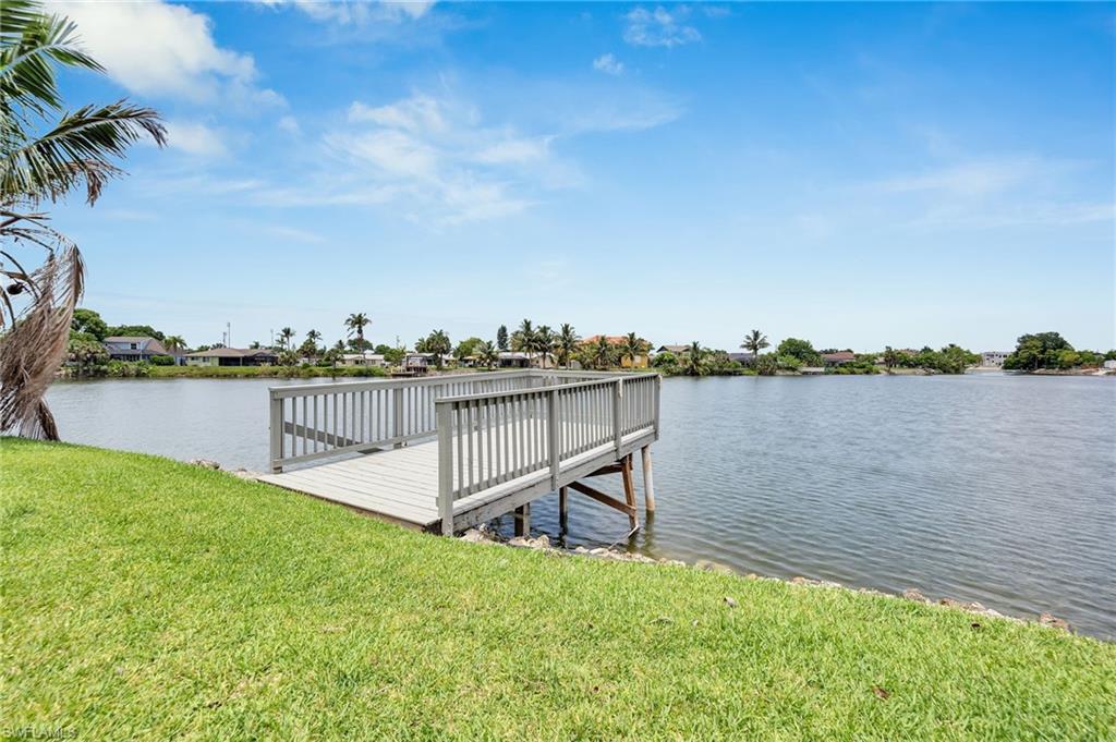 3065 50th Lane Southwest Naples, FL 34116 - Photo 25 of 31 a view of a lake with table and chairs next to a yard