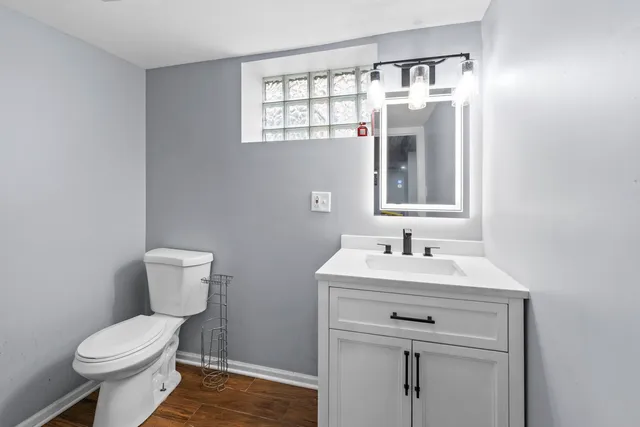 a bathroom with a toilet sink and mirror